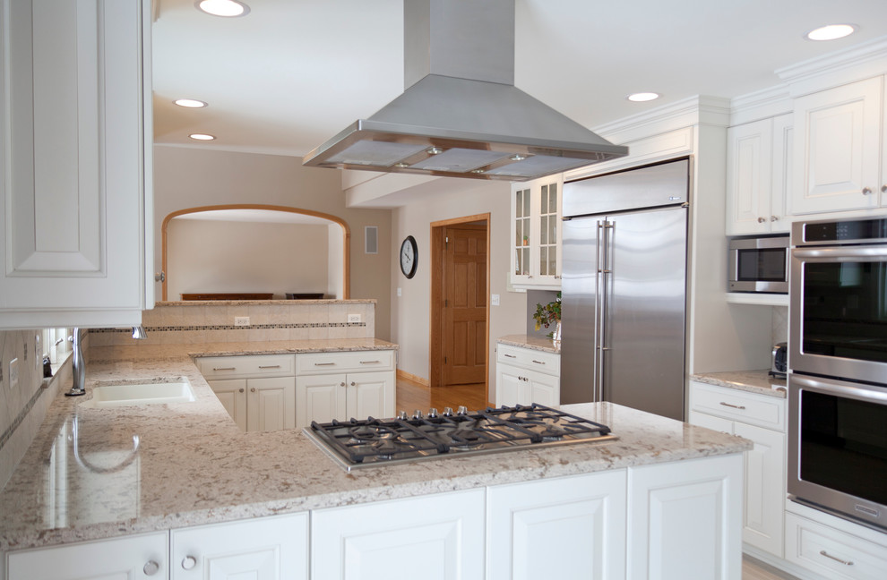 Design ideas for a mid-sized transitional u-shaped kitchen in Chicago with raised-panel cabinets, white cabinets, quartz benchtops, ceramic splashback, stainless steel appliances, porcelain floors, an undermount sink, beige splashback and beige floor.