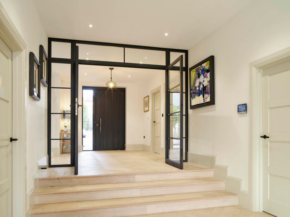 Aménagement d'une entrée contemporaine avec une porte pivot et une porte en bois foncé.