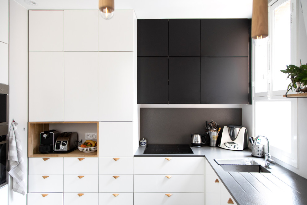 Design ideas for a mid-sized l-shaped open plan kitchen in Other with an undermount sink, flat-panel cabinets, white cabinets, laminate benchtops, black splashback, stone slab splashback, stainless steel appliances, cement tiles, a peninsula, multi-coloured floor and black benchtop.