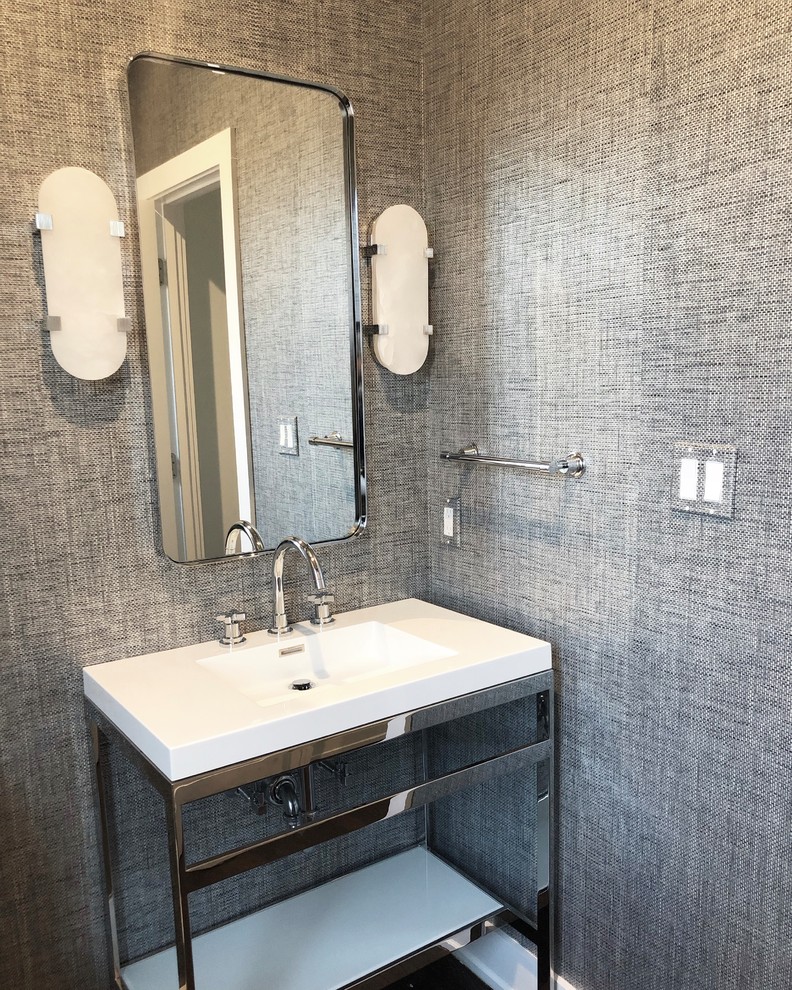 This is an example of a mid-sized contemporary powder room in New York with furniture-like cabinets, white cabinets, grey walls, dark hardwood floors, an integrated sink, solid surface benchtops, brown floor and white benchtops.