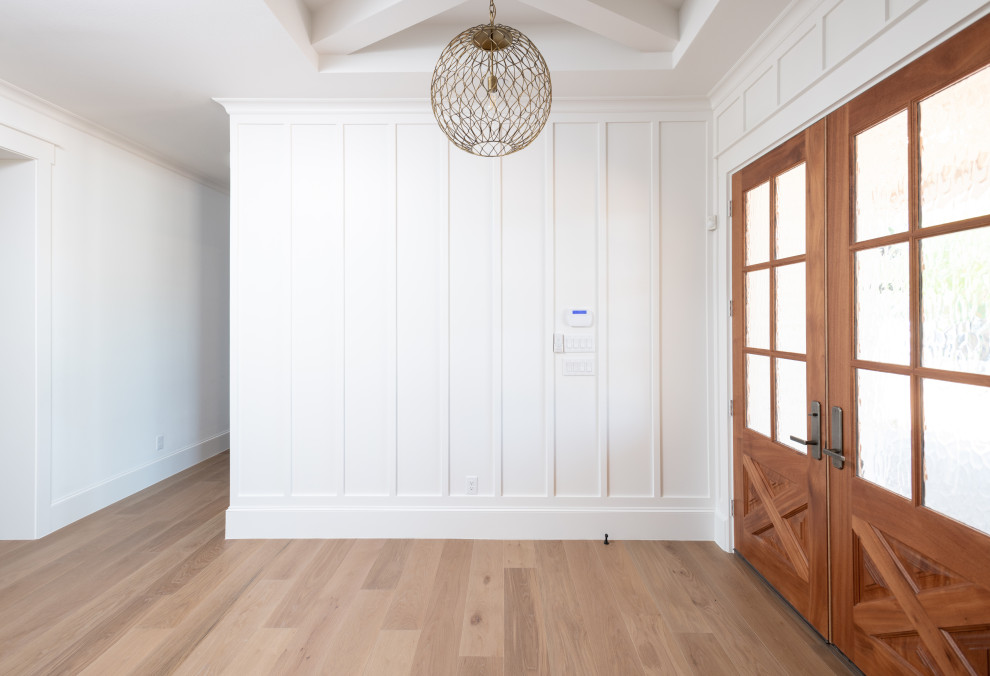 ダラスにある中くらいなカントリー風のおしゃれな玄関ロビー (白い壁、淡色無垢フローリング、木目調のドア、茶色い床、表し梁、羽目板の壁) の写真