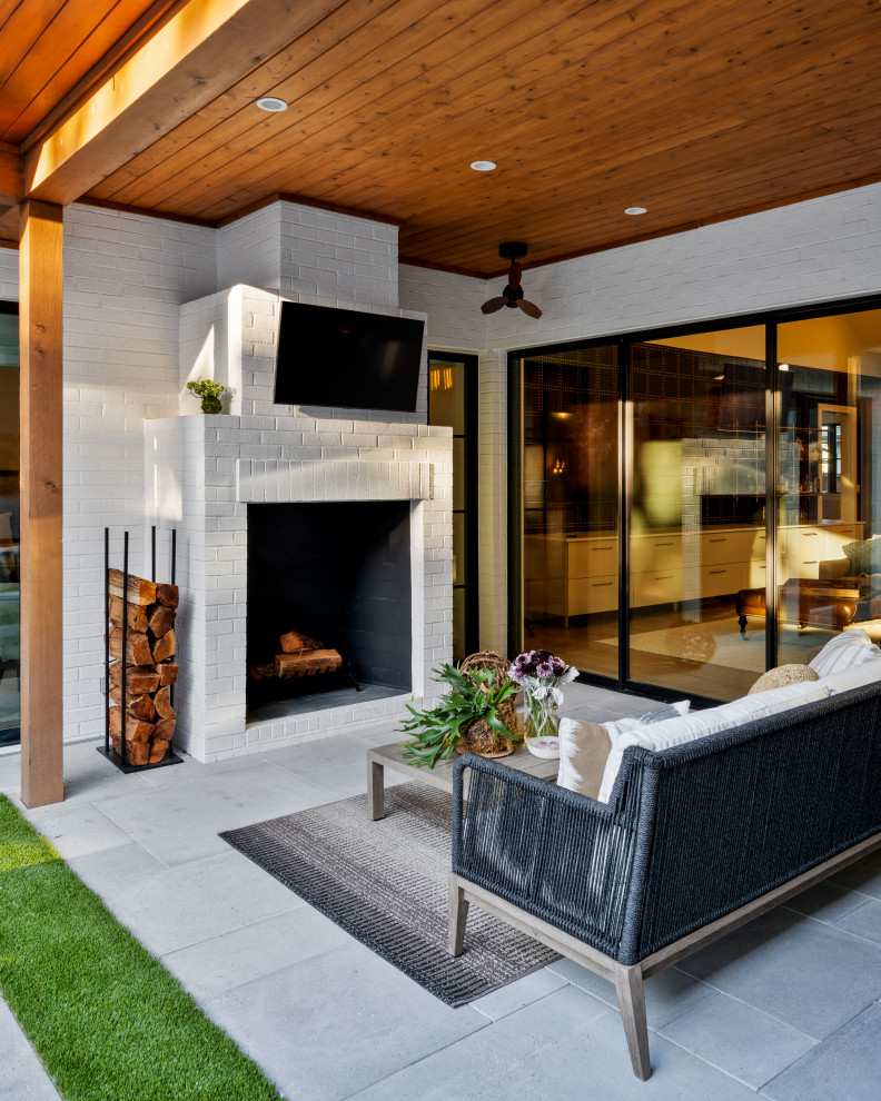 Foto de patio clásico renovado de tamaño medio en patio y anexo de casas con chimenea y adoquines de hormigón