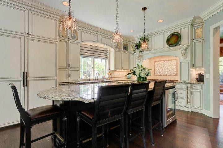Open concept kitchen - transitional single-wall medium tone wood floor open concept kitchen idea in Columbus with a drop-in sink, beaded inset cabinets, white cabinets, granite countertops, stainless steel appliances and an island