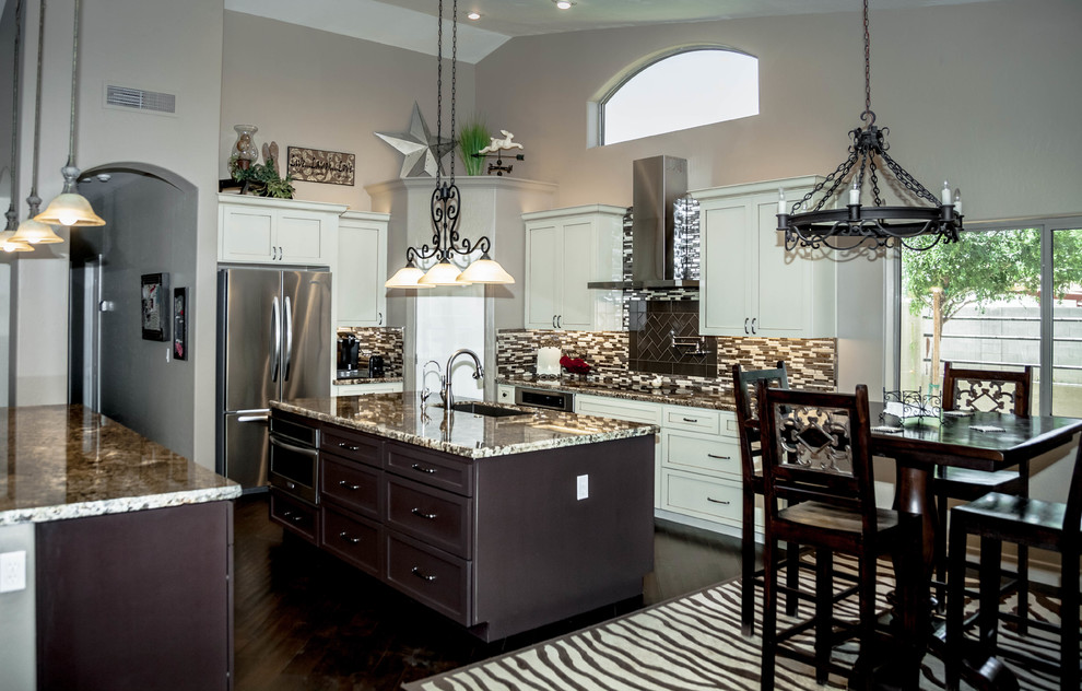 Inspiration for a large transitional l-shaped dark wood floor eat-in kitchen remodel in Phoenix with an undermount sink, white cabinets, granite countertops, multicolored backsplash, glass tile backsplash, stainless steel appliances, recessed-panel cabinets and an island