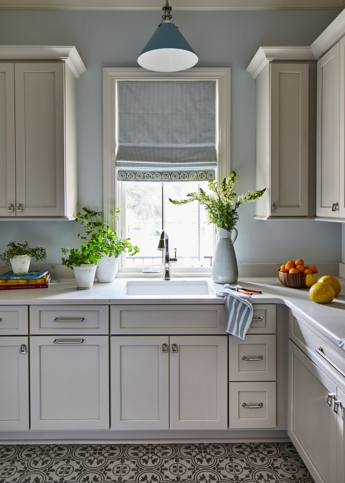 Design ideas for a mid-sized eclectic single-wall utility room in Other with an undermount sink, shaker cabinets, white cabinets, marble benchtops, blue walls, ceramic floors, a side-by-side washer and dryer, grey floor and white benchtop.