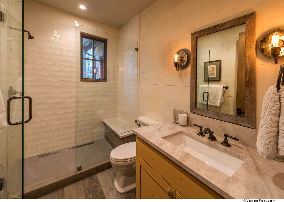Idéer för ett lantligt en-suite badrum, med skåp i shakerstil, gula skåp, en toalettstol med separat cisternkåpa, vit kakel, keramikplattor, vita väggar, klinkergolv i porslin, ett undermonterad handfat, bänkskiva i kvartsit och dusch med gångjärnsdörr