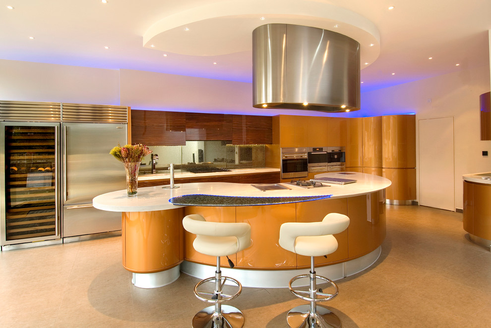 Large contemporary l-shaped eat-in kitchen in London with an integrated sink, flat-panel cabinets, brown cabinets, solid surface benchtops, beige splashback, glass sheet splashback, stainless steel appliances, travertine floors and with island.