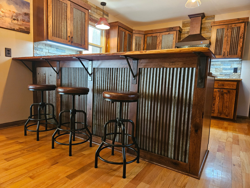 На фото: п-образная кухня среднего размера в стиле рустика с обеденным столом, темными деревянными фасадами и гранитной столешницей с