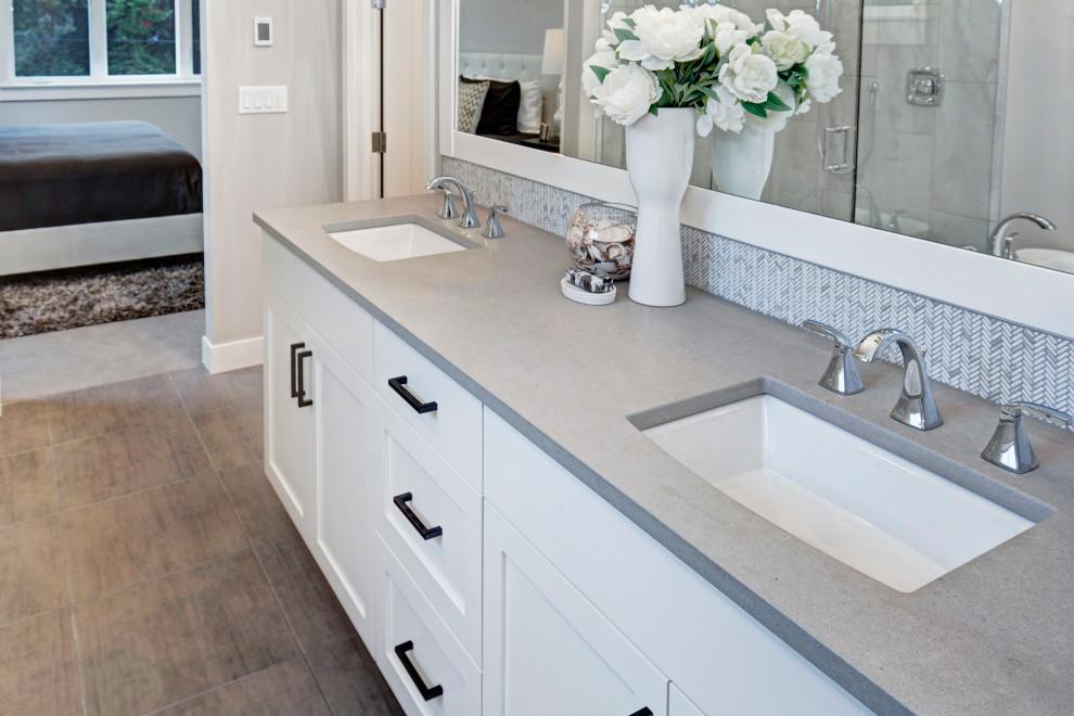 Photo of an arts and crafts master bathroom in Seattle with white cabinets, a freestanding tub, a corner shower, gray tile, porcelain tile, grey walls, porcelain floors, an undermount sink, quartzite benchtops, a hinged shower door and grey benchtops.