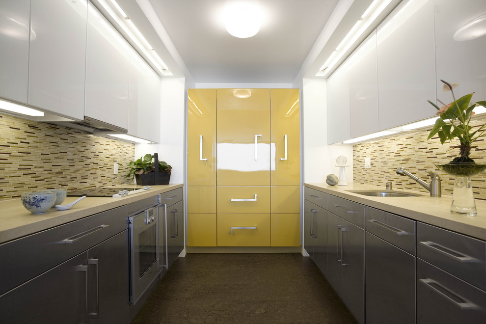 This is an example of a mid-sized contemporary galley separate kitchen in San Francisco with an undermount sink, flat-panel cabinets, yellow cabinets, solid surface benchtops, beige splashback, matchstick tile splashback, stainless steel appliances, cork floors, no island and brown floor.