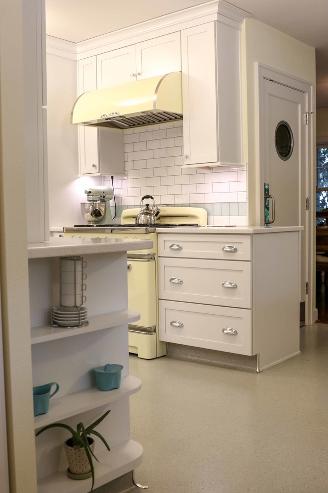 Inspiration for a large traditional u-shaped separate kitchen in Portland with a farmhouse sink, shaker cabinets, white cabinets, quartz benchtops, white splashback, subway tile splashback, coloured appliances, linoleum floors and a peninsula.