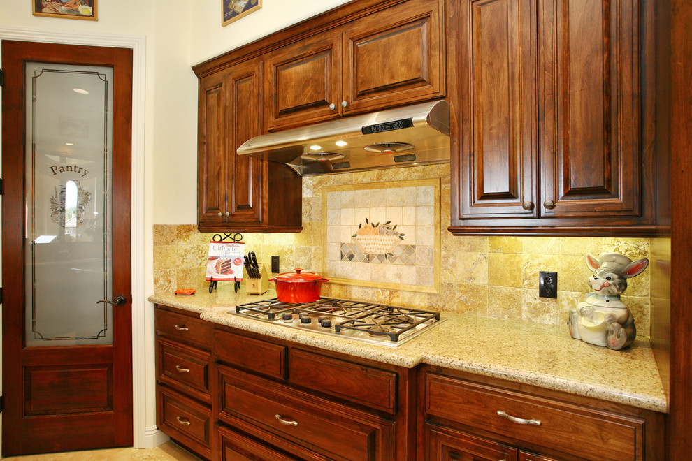 Photo of a mid-sized traditional u-shaped separate kitchen in San Diego with a double-bowl sink, raised-panel cabinets, medium wood cabinets, granite benchtops, beige splashback, stone tile splashback, stainless steel appliances, marble floors and with island.