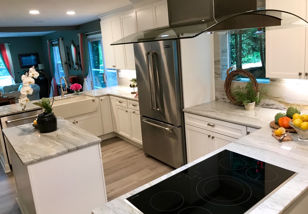 This is an example of a mid-sized transitional u-shaped eat-in kitchen in Portland with a farmhouse sink, shaker cabinets, white cabinets, marble benchtops, white splashback, marble splashback, stainless steel appliances, vinyl floors, multiple islands, grey floor and white benchtop.