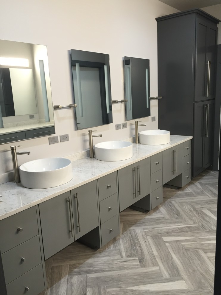 Inspiration for a large transitional master medium tone wood floor and gray floor bathroom remodel in Orange County with flat-panel cabinets, gray cabinets, white walls, a vessel sink, marble countertops and white countertops