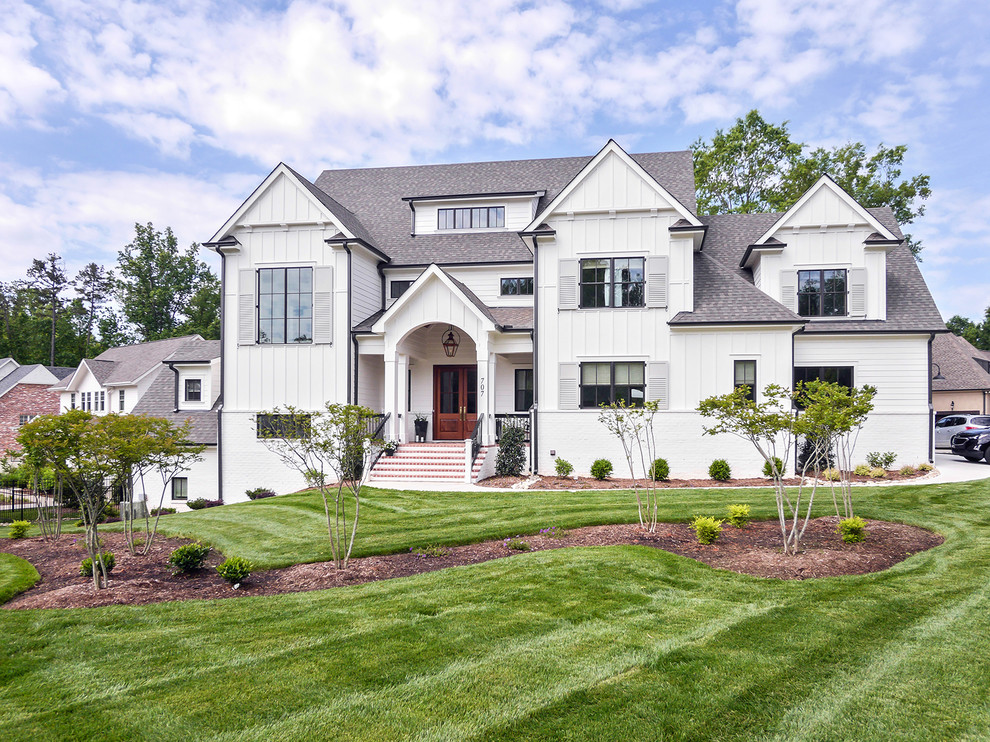 Photo of a large country three-storey brick white house exterior in Charlotte with a gable roof and a mixed roof.