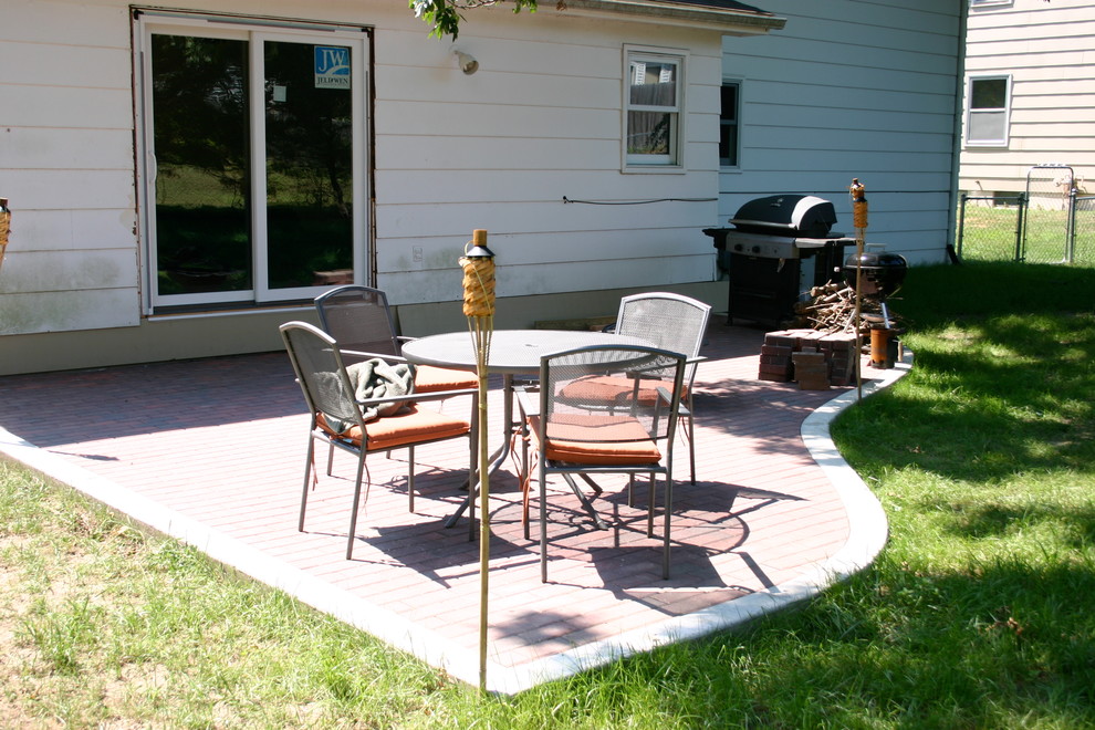 Example of a mid-sized transitional backyard brick patio design with no cover