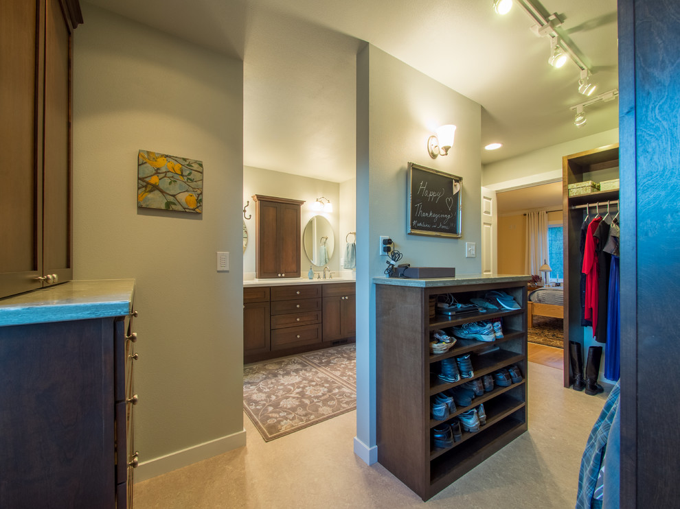 Mid-sized country gender-neutral walk-in wardrobe in Seattle with shaker cabinets, dark wood cabinets, linoleum floors and beige floor.