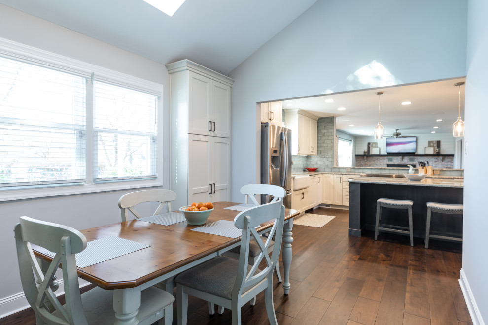 Idée de décoration pour une salle à manger ouverte sur la cuisine tradition de taille moyenne avec un mur bleu, un sol en bois brun, un sol marron et un plafond voûté.