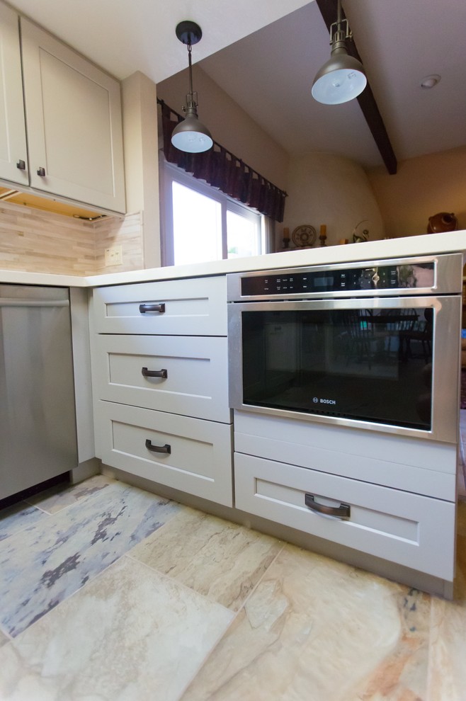 Inspiration for a mid-sized transitional u-shaped porcelain tile kitchen remodel in Phoenix with a farmhouse sink, shaker cabinets, gray cabinets, quartz countertops, gray backsplash, porcelain backsplash, stainless steel appliances and a peninsula