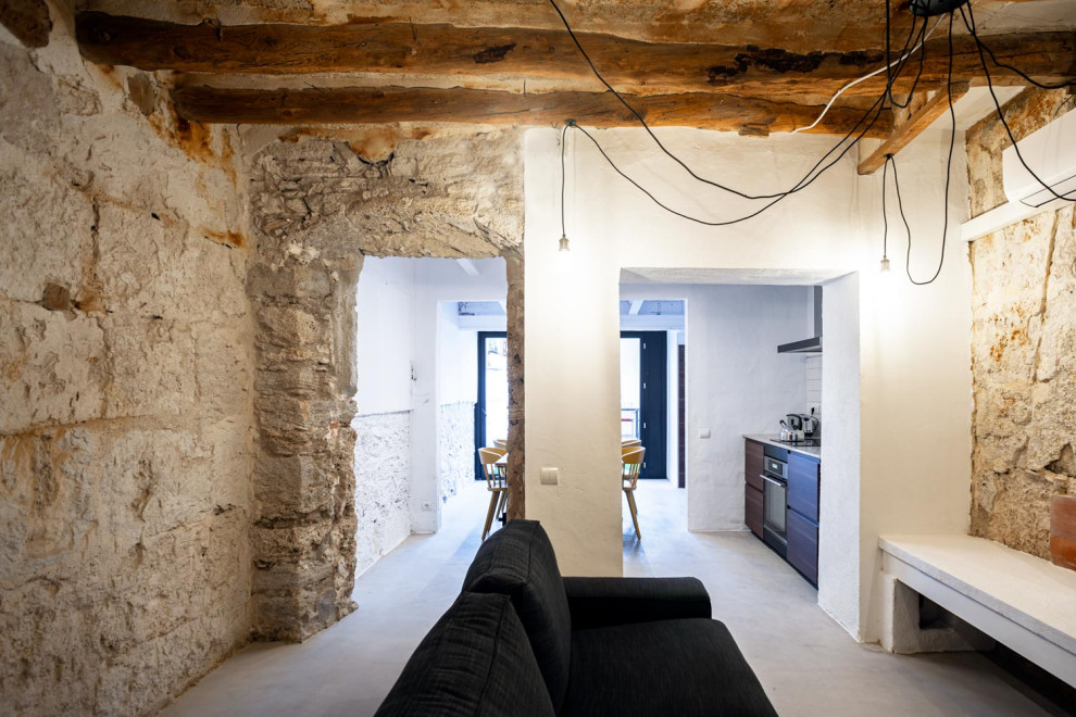 Foto de sala de estar con biblioteca tipo loft mediterránea de tamaño medio con paredes blancas, suelo de madera oscura y vigas vistas