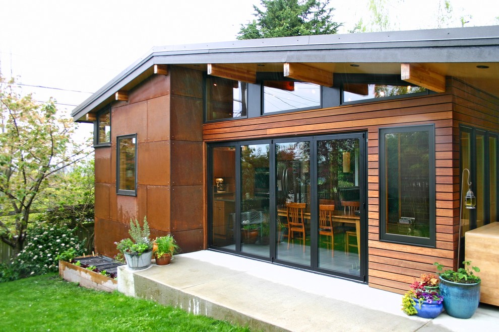 This is an example of a mid-sized contemporary one-storey brown exterior in Seattle with concrete fiberboard siding and a gable roof.