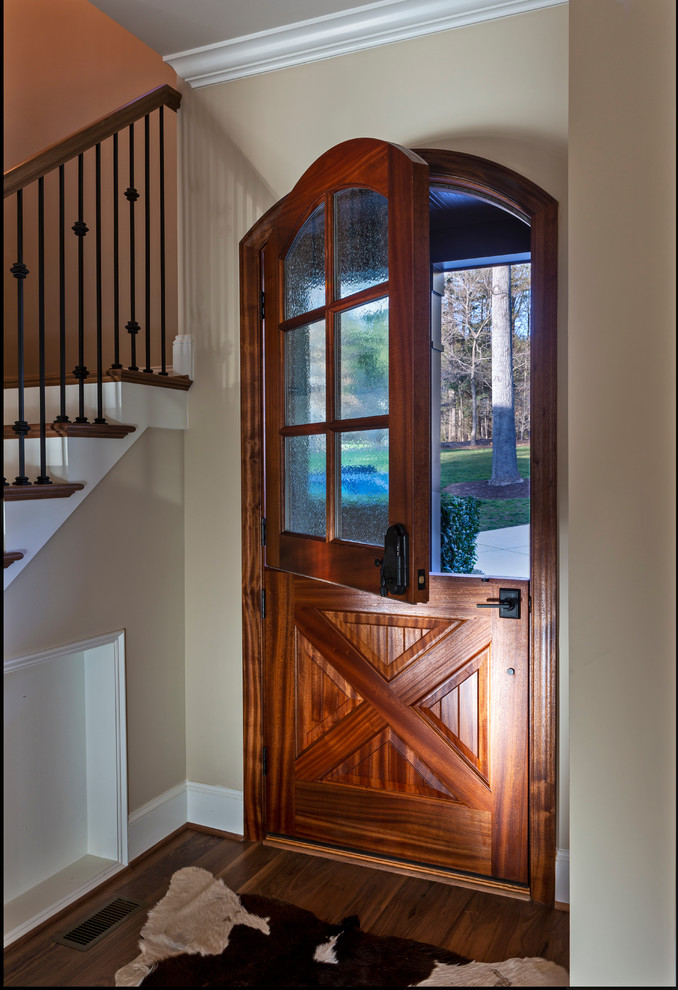 Photo of a country front door in Charlotte with medium hardwood floors, a dutch front door, a medium wood front door and brown floor.