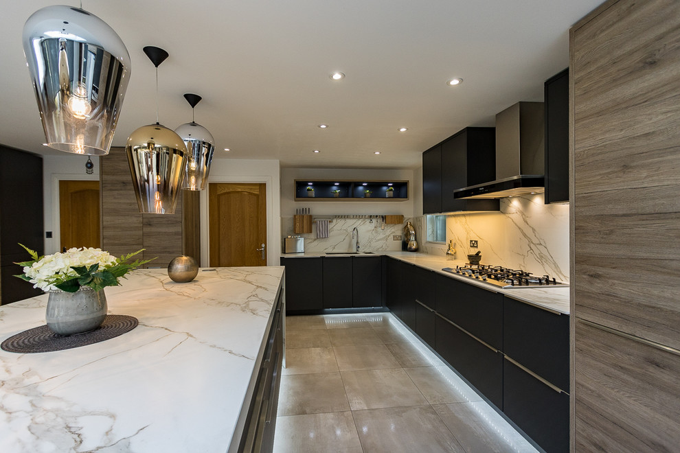 Inspiration for a large modern l-shaped open plan kitchen in Surrey with an integrated sink, flat-panel cabinets, grey cabinets, solid surface benchtops, white splashback, slate splashback, stainless steel appliances, porcelain floors, with island and grey floor.