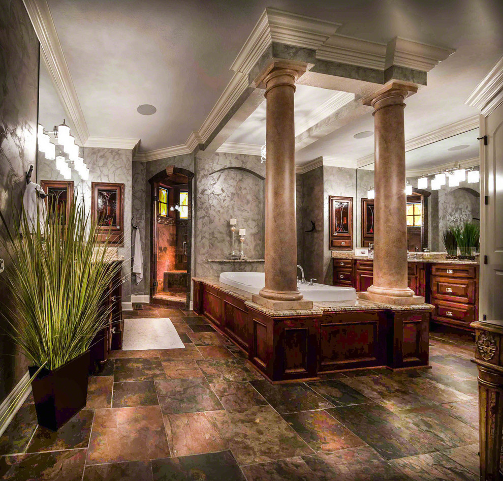 Photo of an expansive eclectic master bathroom in Cleveland with beaded inset cabinets, medium wood cabinets, granite benchtops, a drop-in tub, an open shower, multi-coloured tile, stone tile, grey walls and slate floors.