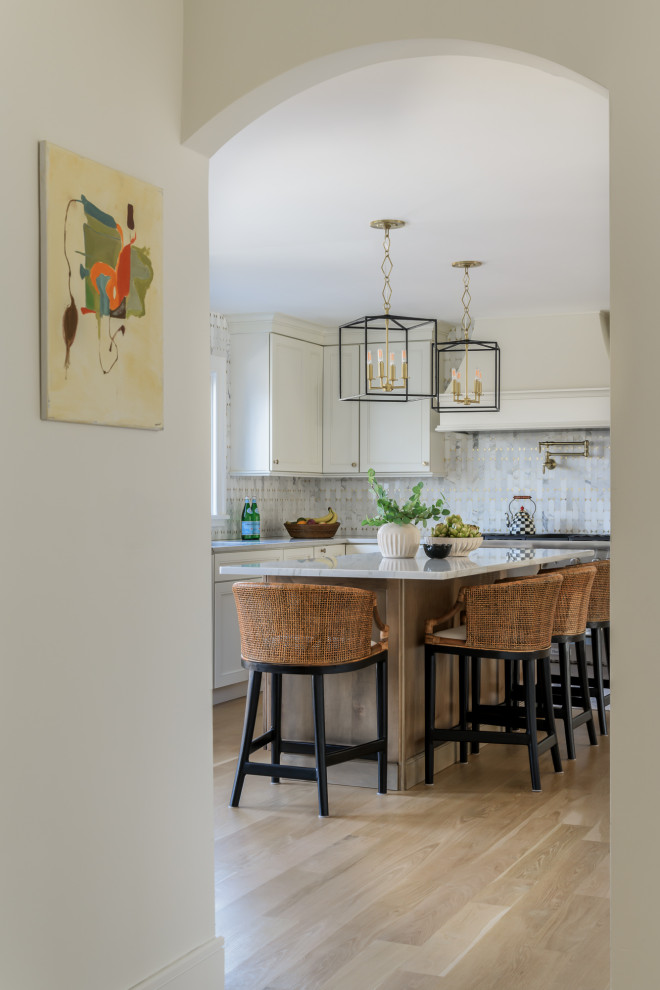 This is an example of a large transitional eat-in kitchen in New York with an undermount sink, shaker cabinets, beige cabinets, quartzite benchtops, multi-coloured splashback, ceramic splashback, panelled appliances, light hardwood floors, with island, brown floor and beige benchtop.