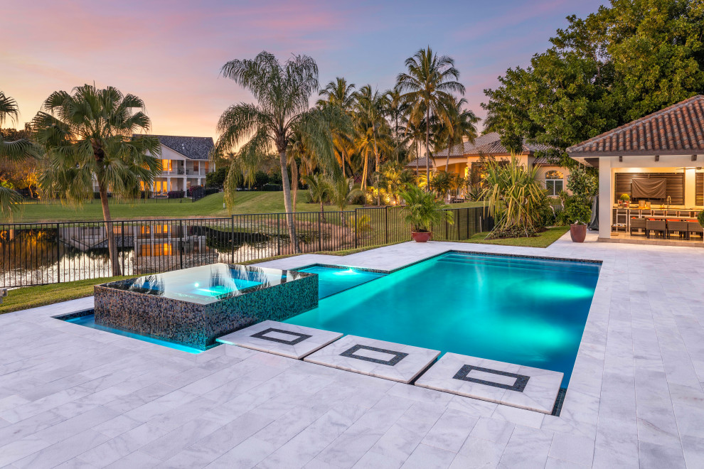 Photo of a mid-sized contemporary backyard rectangular pool in Miami with a hot tub.