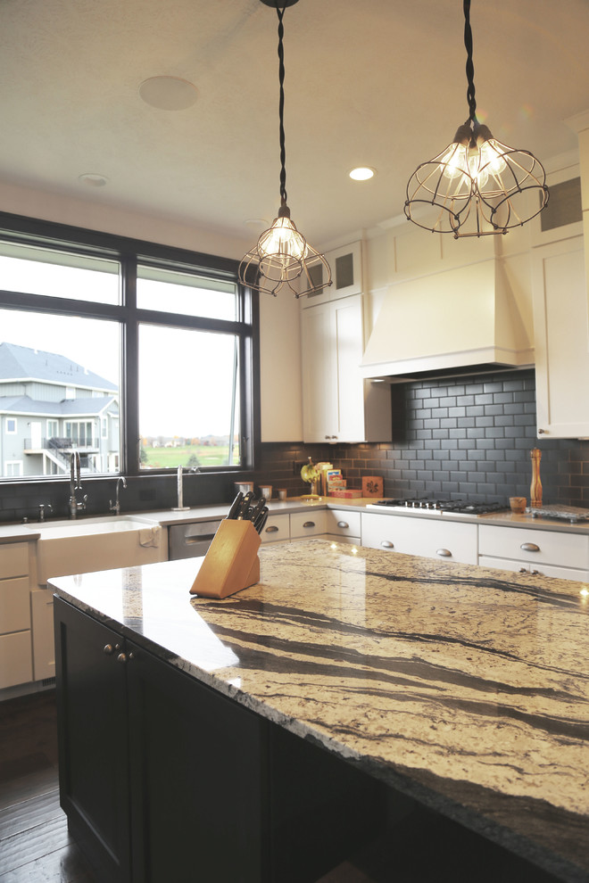 Inspiration for a mid-sized transitional l-shaped dark wood floor eat-in kitchen remodel with a farmhouse sink, recessed-panel cabinets, white cabinets, granite countertops, black backsplash, porcelain backsplash, stainless steel appliances and an island