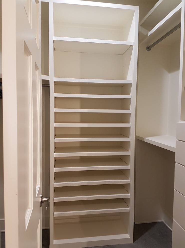 Photo of a large asian women's walk-in wardrobe in Houston with flat-panel cabinets, white cabinets, porcelain floors and grey floor.