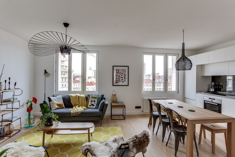 Small scandinavian open concept living room in Lyon with white walls, light hardwood floors and no tv.