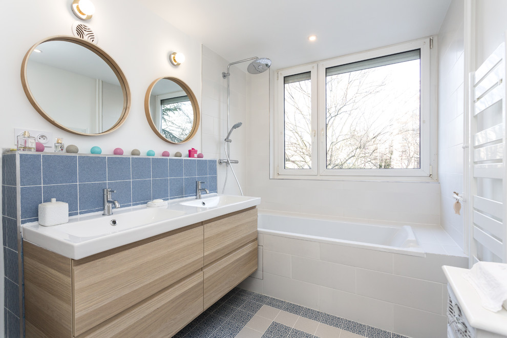 Photo of a mid-sized modern master bathroom in Other with flat-panel cabinets, beige cabinets, an undermount tub, a shower/bathtub combo, blue tile, ceramic tile, white walls, ceramic floors, solid surface benchtops, blue floor, an open shower, white benchtops, a two-piece toilet and a console sink.