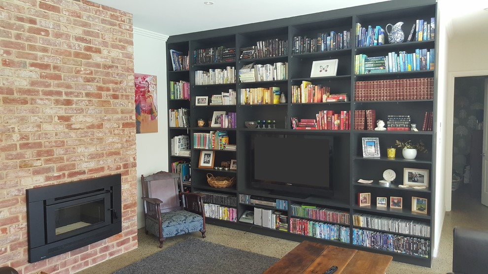 Inspiration for a large modern open concept living room in Adelaide with a library, black walls, concrete floors, a standard fireplace, a brick fireplace surround and a built-in media wall.