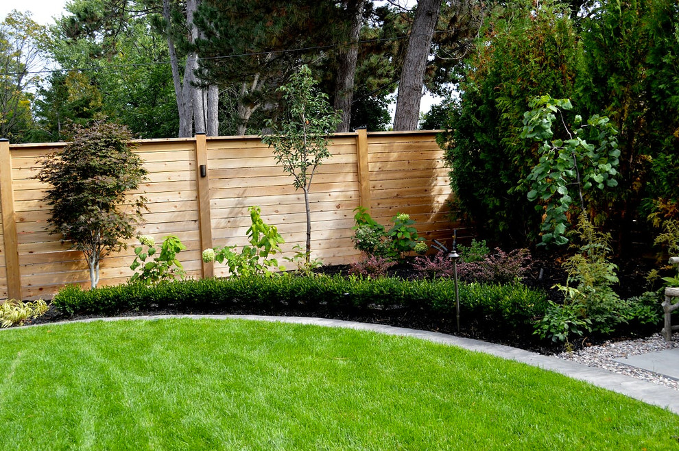 Photo of a large transitional full sun backyard stone formal garden in Toronto.