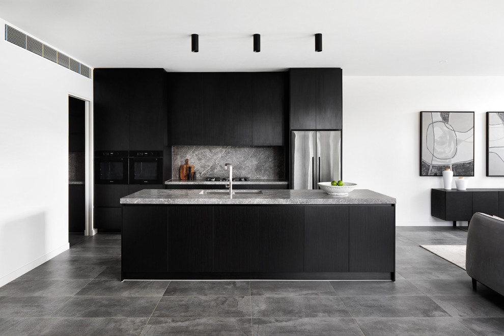 Photo of a contemporary open plan kitchen in Melbourne with an undermount sink, black cabinets, marble benchtops, marble splashback, porcelain floors, with island, flat-panel cabinets, grey splashback, stainless steel appliances, grey floor and grey benchtop.