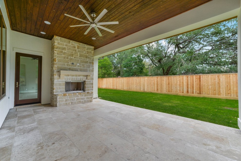 Design ideas for a transitional backyard patio in Houston with a fire feature, tile and a roof extension.