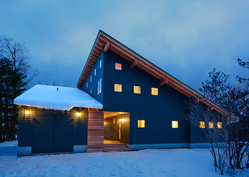 Mountain style green two-story mixed siding house exterior photo with a shed roof and a metal roof