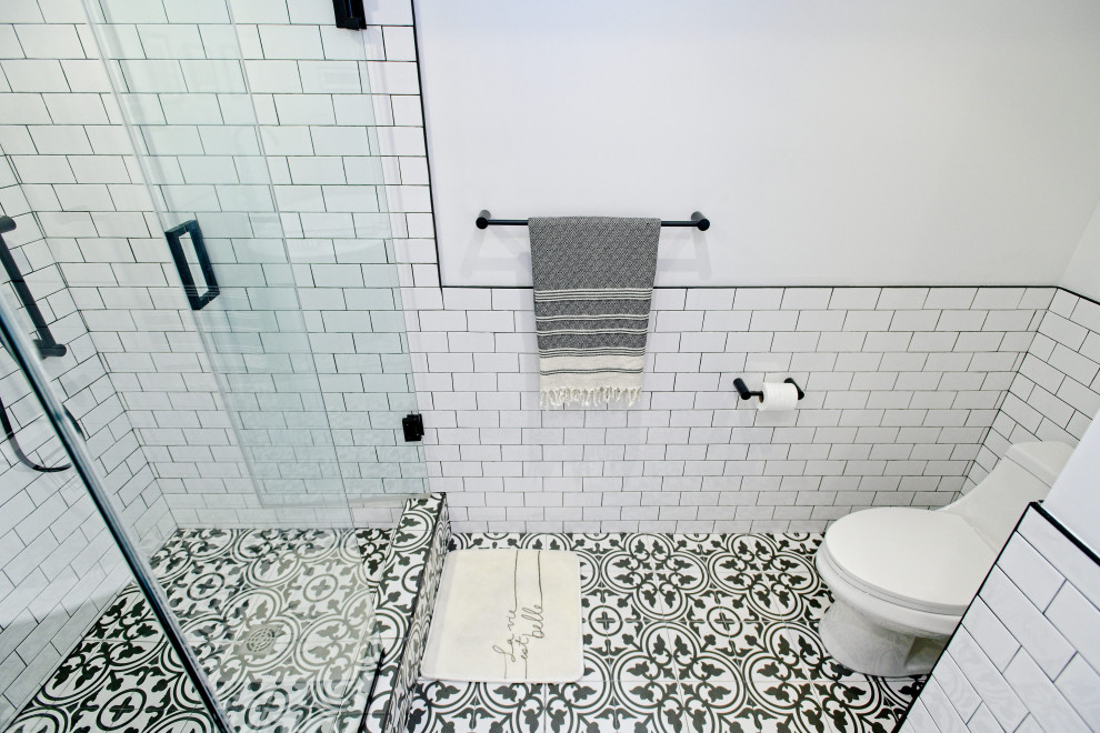 This is an example of a medium sized eclectic ensuite bathroom in Toronto with shaker cabinets, grey cabinets, a freestanding bath, a corner shower, a one-piece toilet, white tiles, metro tiles, white walls, porcelain flooring, a submerged sink, quartz worktops, grey floors, a hinged door, white worktops, a single sink and a built in vanity unit.