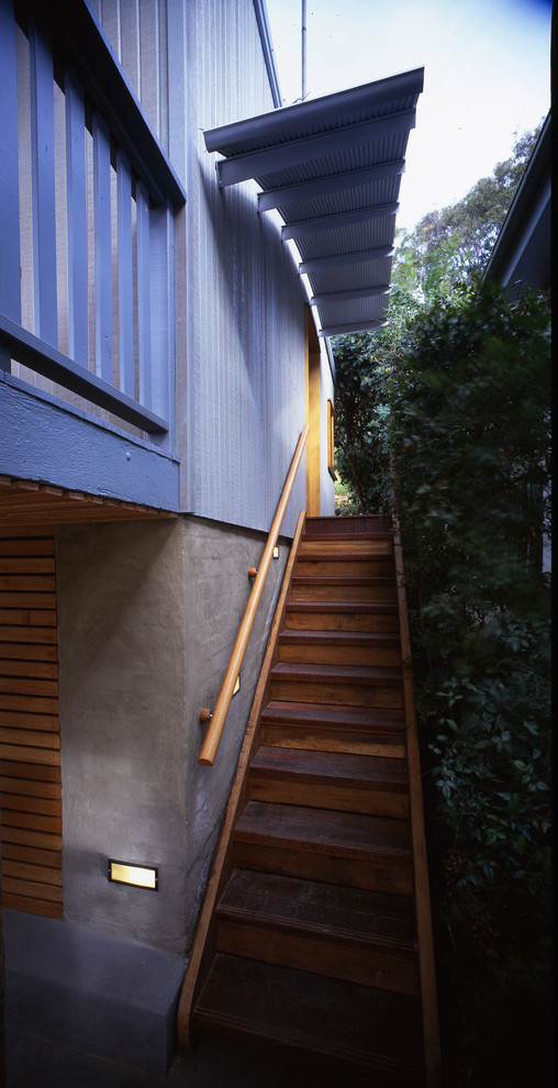 This is an example of a beach style blue exterior in Sydney with wood siding.