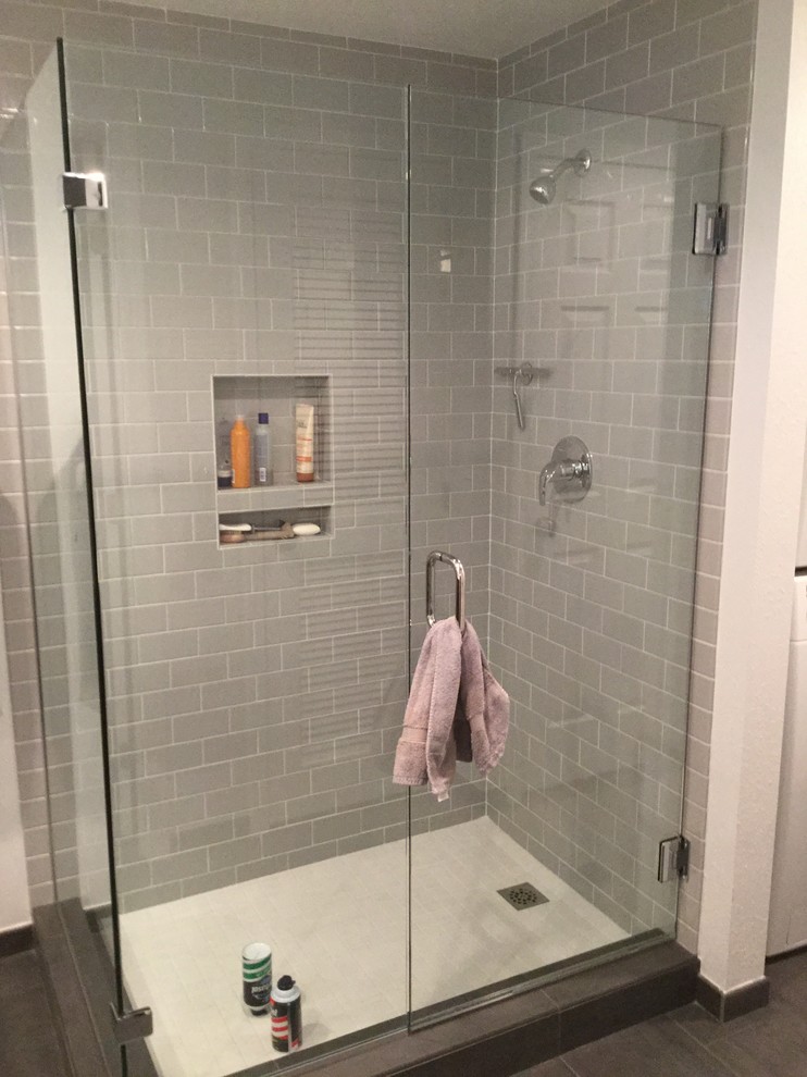 Photo of a mid-sized contemporary 3/4 bathroom in Seattle with an alcove shower, gray tile, subway tile, red walls, porcelain floors, grey floor and a hinged shower door.