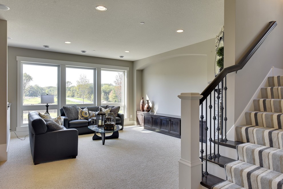 Large transitional walk-out basement in Minneapolis with carpet, a standard fireplace, grey walls and grey floor.