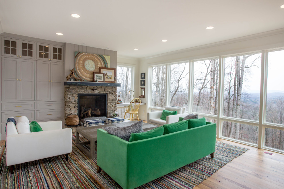 Inspiration for a mid-sized country open concept family room in Other with white walls, a standard fireplace, a stone fireplace surround and light hardwood floors.