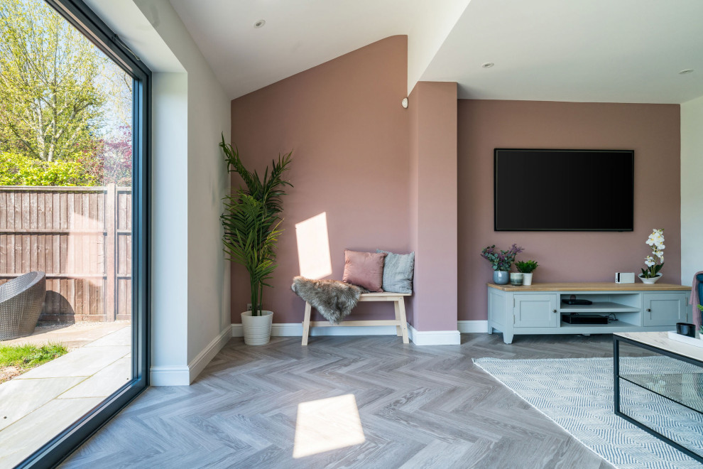 Стильный дизайн: открытая гостиная комната среднего размера в стиле модернизм с серыми стенами, полом из винила, телевизором на стене, серым полом и акцентной стеной без камина - последний тренд