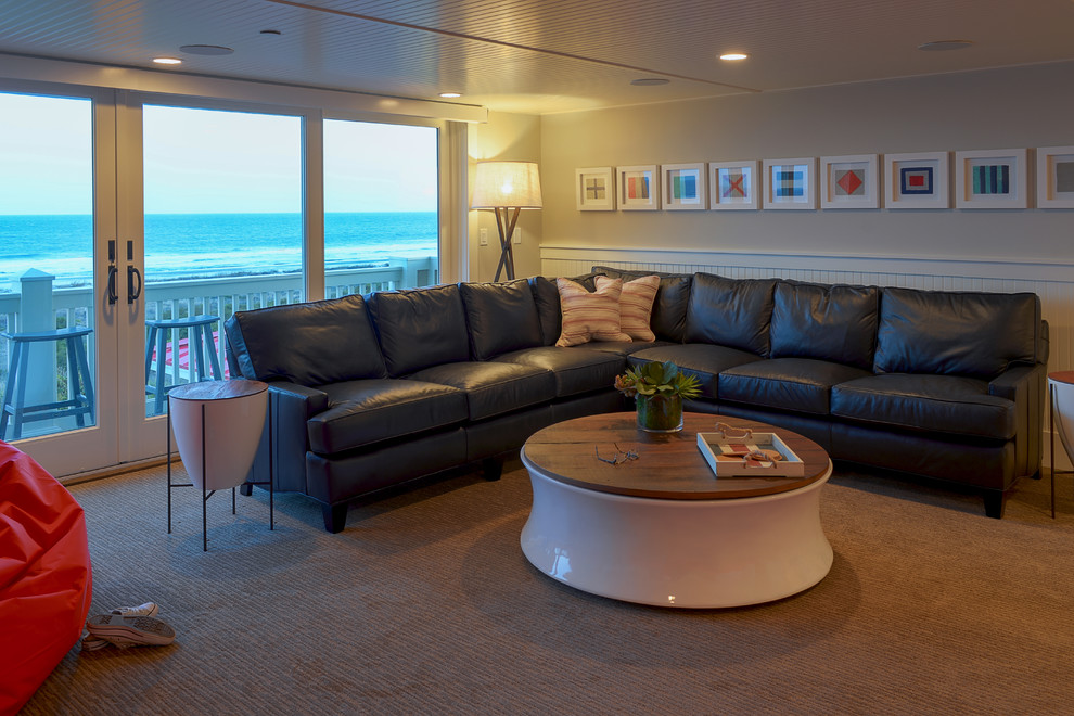 Photo of a mid-sized beach style enclosed home theatre in Charleston with white walls, carpet, a wall-mounted tv and beige floor.