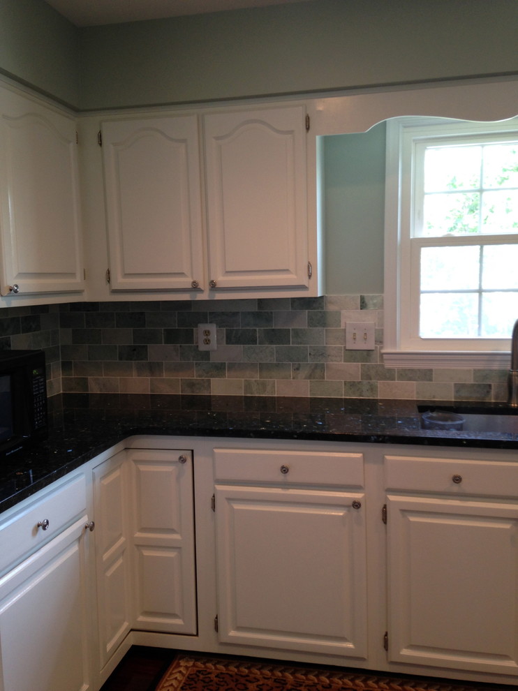Eat-in kitchen - large transitional u-shaped dark wood floor eat-in kitchen idea with a double-bowl sink, raised-panel cabinets, white cabinets, granite countertops, green backsplash, subway tile backsplash, black appliances and a peninsula