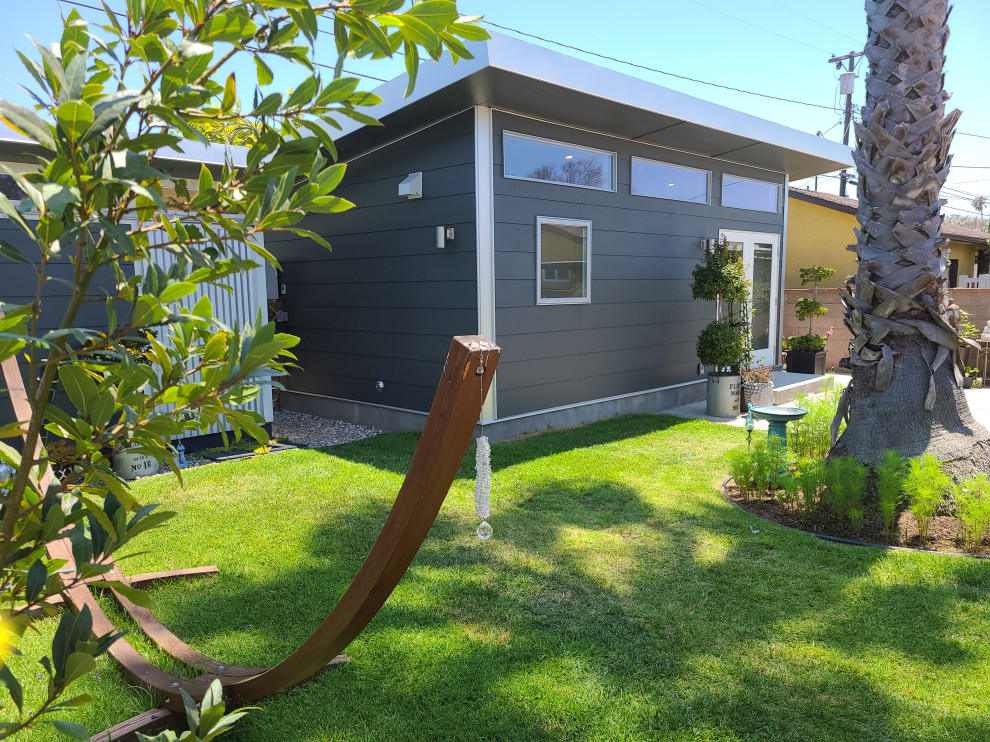 Design ideas for a medium sized and gey retro bungalow tiny house in Los Angeles with concrete fibreboard cladding, a lean-to roof, a metal roof, a grey roof and shiplap cladding.