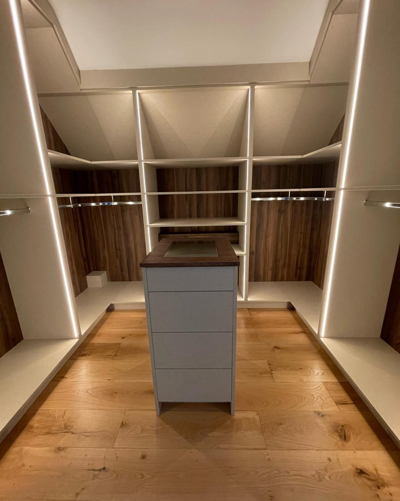 Medium sized contemporary gender neutral walk-in wardrobe in Sussex with open cabinets and feature lighting.