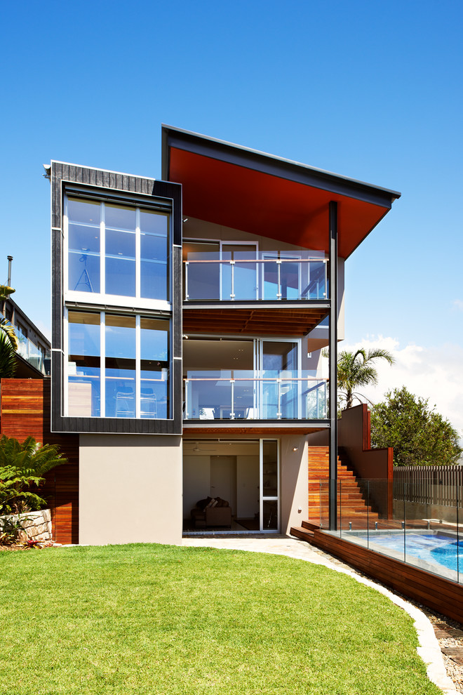 Design ideas for a mid-sized contemporary three-storey beige exterior in Sydney with a shed roof.